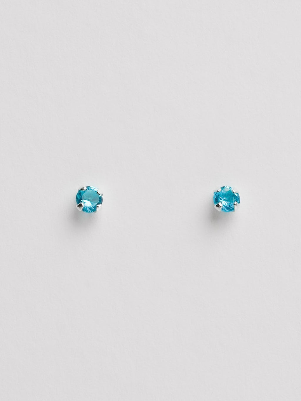 Brinco zircônia redonda azul 3mm garra