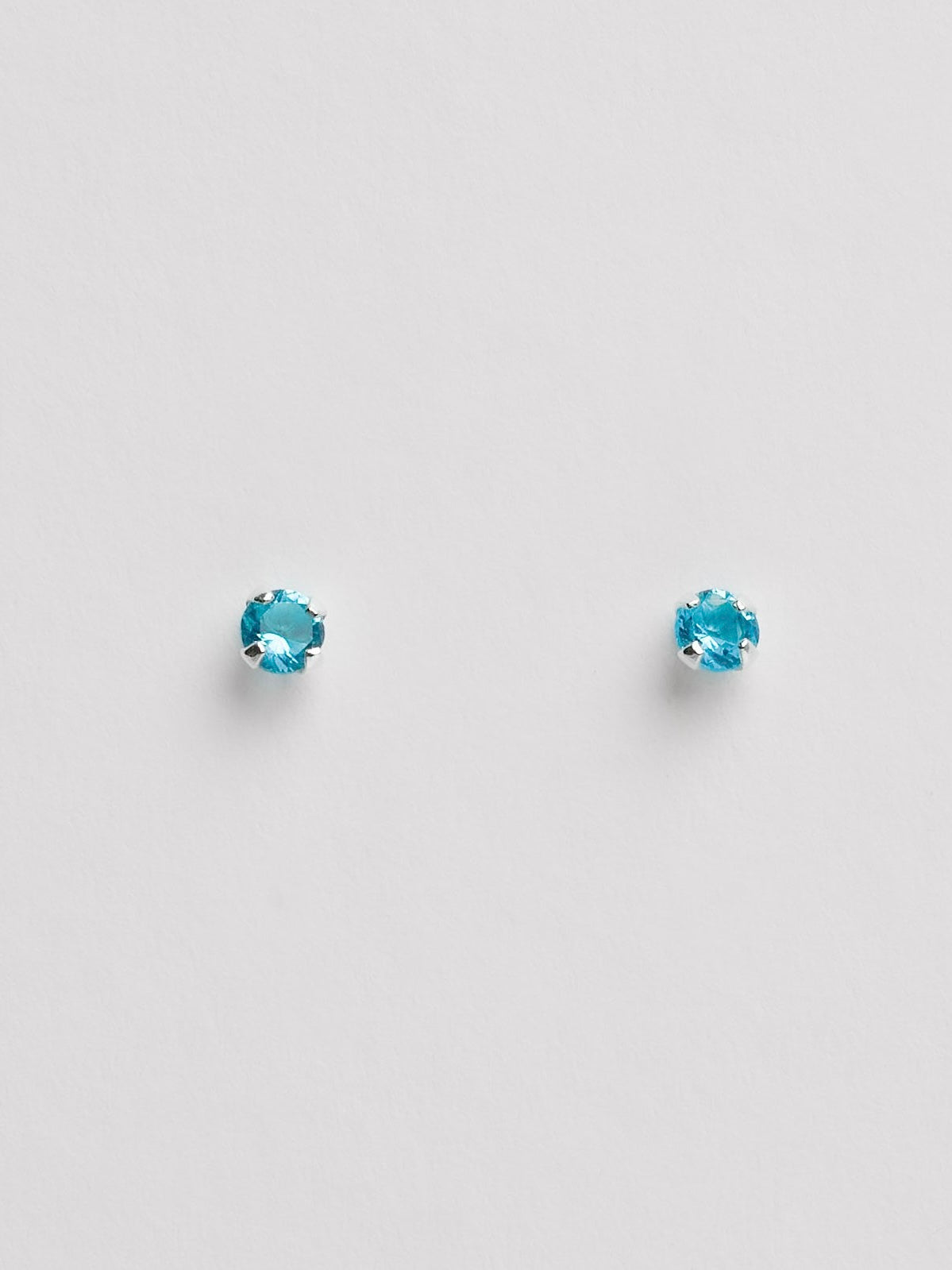 Brinco zircônia redonda azul 3mm garra