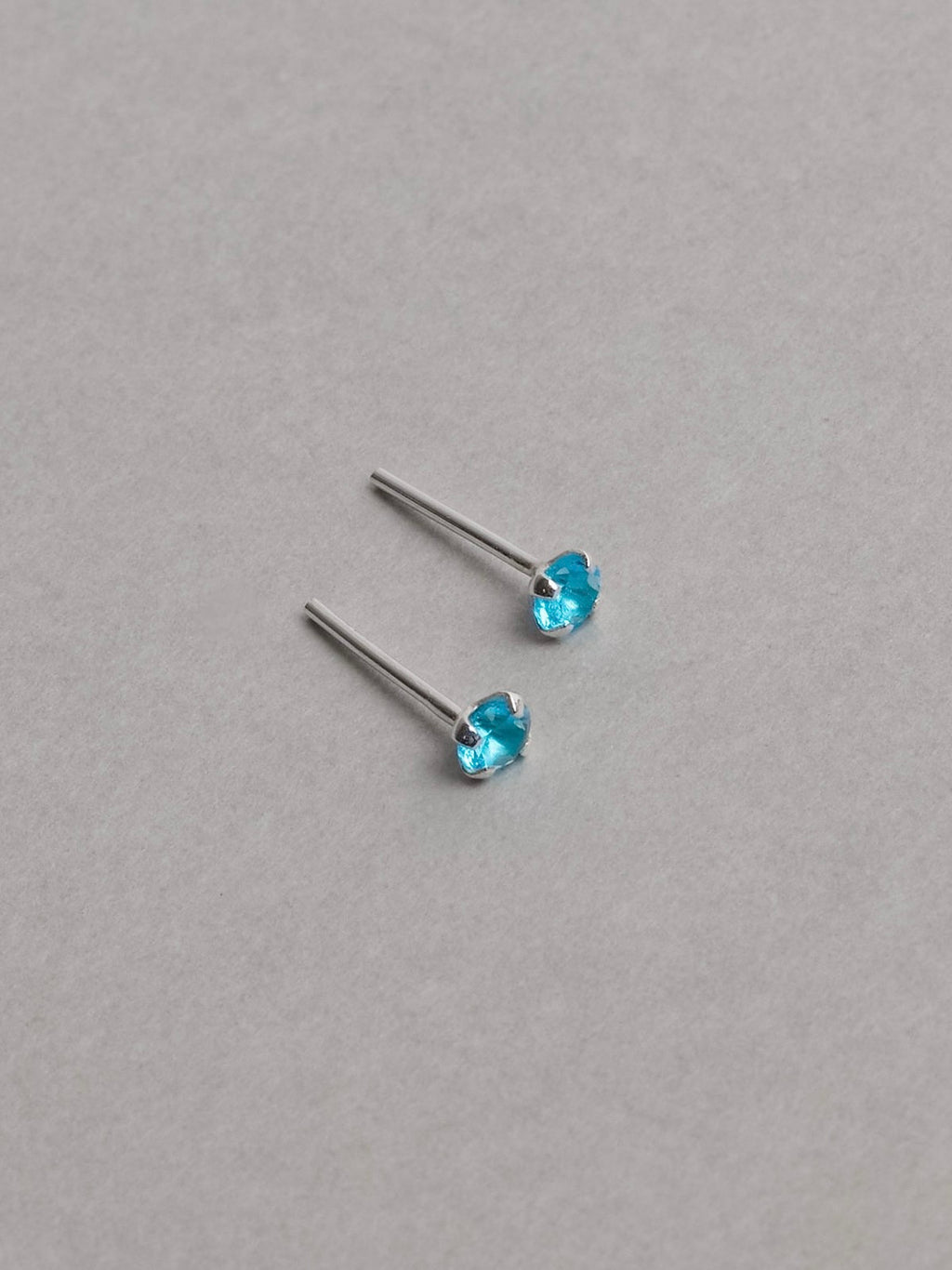 Brinco zircônia redonda azul 3mm garra