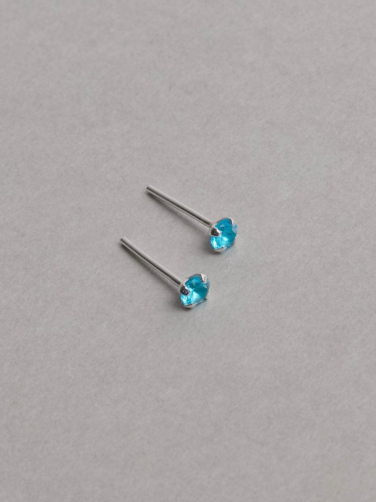 Brinco zircônia redonda azul 3mm garra